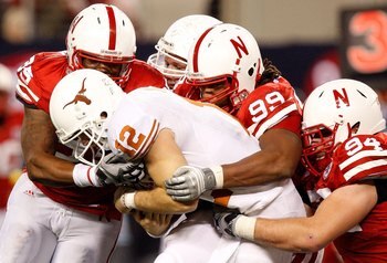 ARLINGTON, TX - DECEMBER 05:  Pierre Allen #95, Barry Turner #99 and Jared Crick #94 of the Nebraska Cornhuskers tackle Colt McCoy #12 of the Texas Longhorns at Cowboys Stadium on December 5, 2009 in Arlington, Texas.  (Photo by Ronald Martinez/Getty Imag