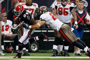 ATLANTA - NOVEMBER 29:  Roddy White #84 of the Atlanta Falcons breaks a tackle by Sabby Piscitelli #21 of the Tampa Bay Buccaneers at Georgia Dome on November 29, 2009 in Atlanta, Georgia.  (Photo by Kevin C. Cox/Getty Images)