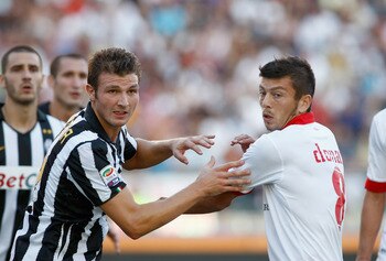 BARI, ITALY - AUGUST 29:  Marco Motta (L) of Juventus FC battles for the ball with Massimo Donati of AS Bari during the Serie A match between Bari and Juventus at Stadio San Nicola on August 29, 2010 in Bari, Italy.  (Photo by Maurizio Lagana/Getty Images