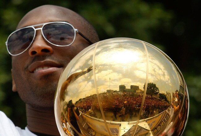 LOS ANGELES, CA - JUNE 21:  The crowd is reflected in the championship trophy held by Los Angeles Lakers guard Kobe Bryant as he rides in the victory parade for the the NBA basketball champion team on June 21, 2010 in Los Angeles, California. The Lakers b