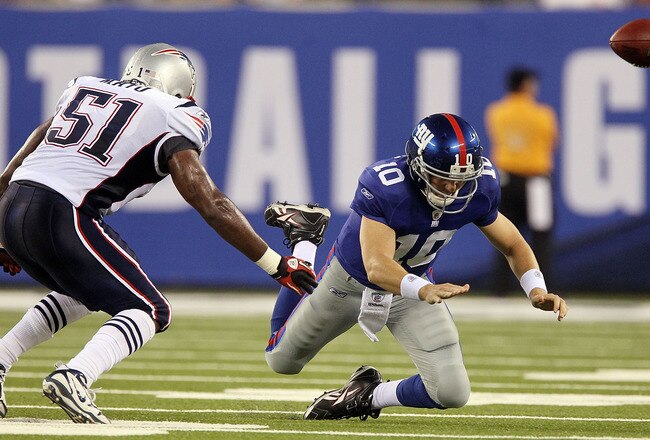EAST RUTHERFORD, NJ - SEPTEMBER 02:  Eli Manning #10 of the New York Giants fumbles the ball in the first quarter as he is pressured by Jerod Mayo #51 of the New England Patriots on September 2, 2010 at the New Meadowlands Stadium in East Rutherford, New 