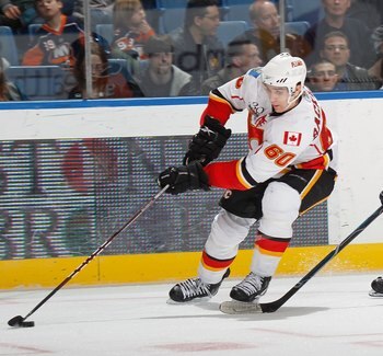 UNIONDALE, NY - MARCH 25:  Mikael Backlund #60 of the Calgary Flames skates with the puck in front of  John Tavares #91 of the New York Islanders during an NHL game at the Nassau Coliseum on March 25, 2010 in Uniondale, New York.  (Photo by Paul Bereswill