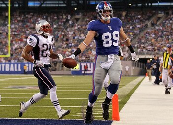 EAST RUTHERFORD, NJ - SEPTEMBER 02:  Kevin Boss #89 of the New York Giants runs in a first quarter touchdown past Patrick Chung #25 of the New England Patriots on September 2, 2010 at the New Meadowlands Stadium in East Rutherford, New Jersey.  (Photo by 