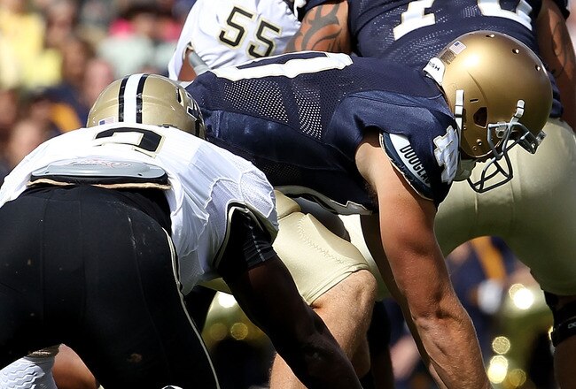 SOUTH BEND, IN - SEPTEMBER 04: Dayne Crist #10 of the Notre Dame Fighting Irish recovers his own fumble under pressure from Gerald Gooden #2 of the Purdue Boilermakers at Notre Dame Stadium on September 4, 2010 in South Bend, Indiana. (Photo by Jonathan D