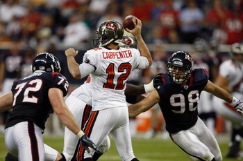 HOUSTON - SEPTEMBER 02:  Quarterback Rudy Carpenter #12 of the Tampa Bay Buccaneers stands in the pocket as he is pressured by defensive ends Jesse Nading #72 and Connor Barwin #98 of the Houston Texans at Reliant Stadium on September 2, 2010 in Houston,