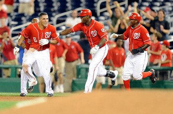 WASHINGTON - AUGUST 26:  Ian Desmond #6 of the Washington Nationals celebrates with Roger Bernadina #2 and Nyjer Morgan #1 after driving in the game winning run in the thirteenth inning against the St. Louis Cardinals at Nationals Park on August 26, 2010