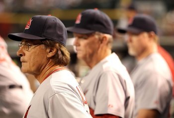 PHOENIX - JUNE 11:  Manager Tony La Russa #10 of the St. Louis Cardinals stands with Dave Duncan #18 and Mark McGwire #25 in the dugout during the Major League Baseball game against the Arizona Diamondbacks at Chase Field on June 11, 2010 in Phoenix, Ariz
