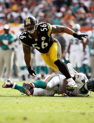 MIAMI - JANUARY 03:  Linebacker LaMarr Woodley #56 of the Pittsburgh Steelers tries to get into the backfield after running over running back Ricky Williams #34 of the Miami Dolphins at Land Shark Stadium on January 3, 2010 in Miami, Florida.  (Photo by D