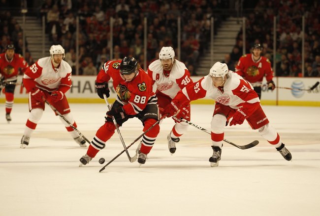CHICAGO - APRIL 11: Patrick Kane #88 of the Chicago Blackhawks skates past Valtteri Filppula #51 and Henrik Zetterberg #40 of the Detroit Red Wings at the United Center on April 11, 2010 in Chicago, Illinois. The Red Wings defeated the Blackhawks 3-2 in o
