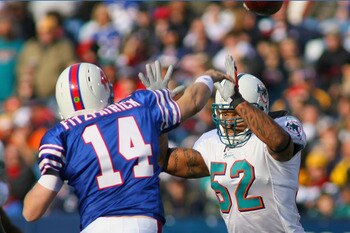 ORCHARD PARK, NY - NOVEMBER 29:  Ryan Fitzpatrick #14 of the Buffalo Bills is pressured by Channing Crowder #52 of the Miami Dolphins at Ralph Wilson Stadium on November 29, 2009 in Orchard Park, New York. Buffalo won 31-14.  (Photo by Rick Stewart/Getty
