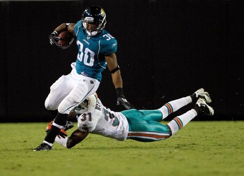 JACKSONVILLE, FL - AUGUST 21:  Nate Ness #31 of the Miami Dolphins attempts to tackle Scotty McGee #30 of the Jacksonville Jaguars during the preseason game at EverBank Field on August 21, 2010 in Jacksonville, Florida.  (Photo by Sam Greenwood/Getty Imag