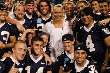 NEW HAVEN, CT - AUGUST 25:  Caroline Wozniacki of Denmark poses with members of the Yale football team in attendance for her match with Dominika Cibulkova of Slovakia during the Pilot Pen tennis tournament at the Connecticut Tennis Center on August 25, 20