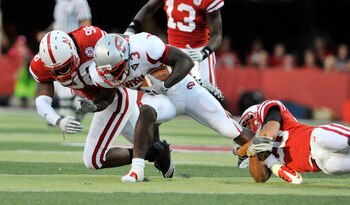 LINCOLN, NE - SEPTEMBER 04:  Bobby Rainey #3 of the Western Kentucky Hilltoppers gets brought down by Josh Williams #98 and Eric Hagg #28 of the Nebraska Cornhuskers during first half action of their game at Memorial Stadium on September 4, 2010 in Lincol