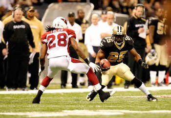 NEW ORLEANS - JANUARY 16:  Reggie Bush #25 of the New Orleans Saints runs the ball against Greg Toler #28 of the Arizona Cardinals during the NFC Divisional Playoff Game at Louisana Superdome on January 16, 2010 in New Orleans, Louisiana. The Saints won 4