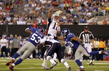 EAST RUTHERFORD, NJ - SEPTEMBER 02:  Tom Brady #12 of the New England Patriots throws a touchdown pass in the first quarter against the New York Giants to teammate Rob Gronkowski  (not pictured) on September 2, 2010 at the New Meadowlands Stadium in East