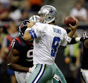 HOUSTON - AUGUST 28: Quarterback Tony Romo #9 of the Dallas Cowboys looks fora receiver as he receives some pressure from defensive tackle Amobi Akoye #91 of the Houston Texans during a football game against the Houston Texans at Reliant Stadium on August