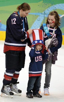 VANCOUVER, BC - FEBRUARY 25:  Jenny Potter #12 of the United States is joined by her children as she received her silver medal  in the medal ceremony following the ice hockey women's gold medal game between Canada and USA on day 14 of the Vancouver 2010 W