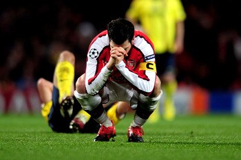 LONDON, ENGLAND - MARCH 31:  Cesc Fabregas of Arsenal reacts after being shown a yellow card by referee Massimo Busacca of Switerland during the UEFA Champions League quarter final first leg match between Arsenal and FC Barcelona at the Emirates Stadium o
