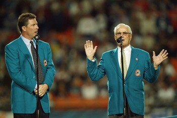 MIAMI - DECEMBER 15:  Former Miami Dolphins coach Don Shula (right) speaks to the crowd as former quarterback Dan Marino watches before inducting former wide receivers Mark Clayton and Mark Duper into the Miami Dolphins Hall of Fame during half time of th