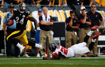 PITTSBURGH - SEPTEMBER 12:  Rashard Mendenhall #26 of the Pittsburgh Steelers runs past Erik Coleman #26 of the Atlanta Falcons for a 50-yard game winning touchdown in overtime during the NFL season opener game on September 12, 2010 at Heinz Field in Pitt