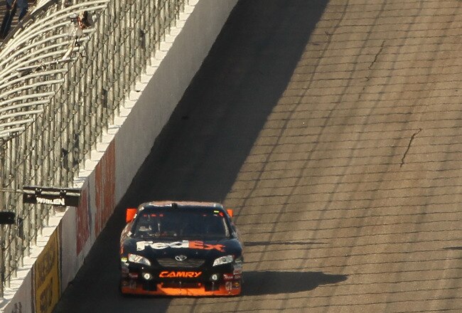 LOUDON, NH - SEPTEMBER 19:  Clint Bowyer, driver of the #33 Cheerios / Hamburger Helper Chevrolet, crosses the start / finish line to take the checkered flag and win ahead of Denny Hamlin, driver of the #11 FedEx Small Business Toyota, during the NASCAR S