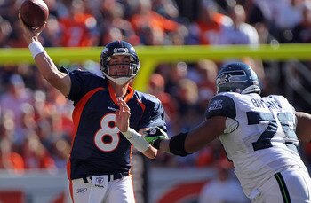 DENVER - SEPTEMBER 19:  Quarterback Kyle Orton #8 of the Denver Broncos gets off a pass while under pressure from defensive end Red Bryant #79 of the Seattle Seahawks at INVESCO Field at Mile High on September 19, 2010 in Denver, Colorado. The Broncos def