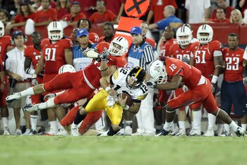 TUCSON, AZ - SEPTEMBER 18:  Quarterback Ricky Stanzi #12 of the Iowa Hawkeyes is tackled by Paul Vassallo #41 and Adam Hall #12 of the Arizona Wildcats during the college football game at Arizona Stadium on September 18, 2010 in Tucson, Arizona.  The Wild