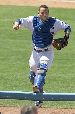 LOS ANGELES - JULY 25:   Catcher Russell Martin #55 of the Los Angeles Dodgers jumps onto a rail beside the New York Mets dugouts as he pursues a pop foul ball that fell into the stands on July 25, 2010 at Dodger Stadium in Los Angeles, California.   The