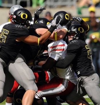 EUGENE, OR - SEPTEMBER 04: Linebacker Casey Matthews #55 of the Oregon Ducks (L) and free safety John Boyett #20 of the Oregon Ducks (R) gang up to tackle running back Demond Dennis #1 of the New Mexico Lobos in the first quarter of the game at Autzen Sta