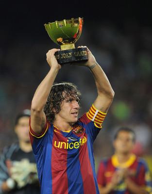 BARCELONA, SPAIN - AUGUST 25:  Carles Puyol of Barcelona holds the Joan Gamper Trophy after his team beat AC Milan in the Joan Gamper Trophy match between Barcelona and AC Milan at Camp Nou stadium on August 25, 2010 in Barcelona, Spain.  (Photo by Denis