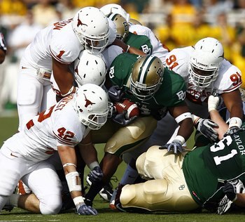 WACO, TX - NOVEMBER 14:  Running back Terrance Ganaway #24 of the Baylor Bears carries the ball against linebacker Dusting Earnest #42, linebacker Keenan Robinson #1, and tackle Kheeston Randall #91of the Texas Longhorns  during the second half on Novembe