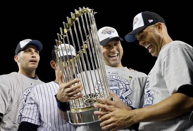 NEW YORK - NOVEMBER 04:  (L-R) Andy Pettitte #46, Jorge Posada #20, Derek Jeter #2 and Mariano Rivera #42 of the New York Yankees celebrate with the trophy after their 7-3 win against the Philadelphia Phillies in Game Six of the 2009 MLB World Series at Y