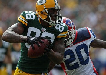 GREEN BAY, WI - SEPTEMBER 19: Jermichael Finley #88 of the Green Bay Packers grabs a pass in front of Donte Whitner #20 of the Buffalo Bills at Lambeau Field on September 19, 2010 in Green Bay, Wisconsin. The Packers defeated the Bills 34-7. (Photo by Jon