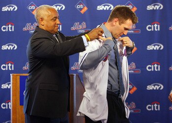 NEW YORK - JANUARY 05:  General manager Omar Minaya helps Jason Bay try on his jersey during a press conference to announce Bay's signing to the New York Mets on January 5, 2010 at Citi Field in the Flushing neighborhood of the Queens borough of New York