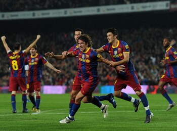 BARCELONA, SPAIN - OCTOBER 16:  Carles Puyol (C) of Barcelona celebrates scoring his sides second goal with his teammates Sergio Busquets (L) and David Villa (R) during the La Liga match between Barcelona and Valencia at the Camp Nou stadium on October 16