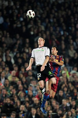 BARCELONA, SPAIN - OCTOBER 16:  Sofiane Feghouli of Valencia (L) and Sergio Busquets of Barcelona duels for a high ball during the La Liga match between Barcelona and Valencia at the Camp Nou stadium on October 16, 2010 in Barcelona, Spain.  (Photo by Dav