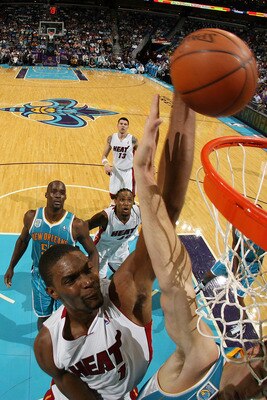 NEW ORLEANS - OCTOBER 13:  Chris Bosh #1 of the Miami Heat dunks the ball over Jason Smith #14 of the New Orleans Hornets at the New Orleans Arena on October 13, 2010 in New Orleans, Louisiana.  The Hornets defeated the Heat 90-76.   NOTE TO USER: User ex