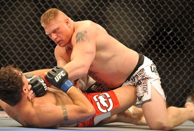 LAS VEGAS - JULY 11:  Brock Lesnar holds down Frank Mir during their heavyweight title bout during UFC 100 on July 11, 2009 in Las Vegas, Nevada. Lesnar defeated Mir by a second round knockout.  (Photo by Jon Kopaloff/Getty Images)