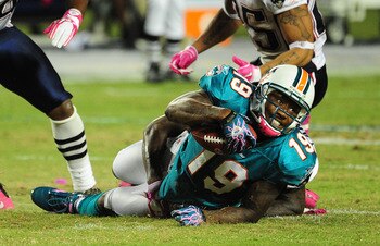 MIAMI - OCTOBER 4: Brandon Marshall #19 of the Miami Dolphins is tackled by Kyle Arrington #27 of the New England Patriots at Sun Life Field on October 4, 2010 in Miami, Florida. (Photo by Scott Cunningham/Getty Images)