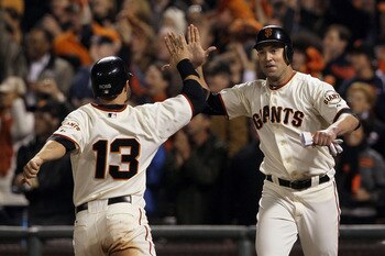 SAN FRANCISCO - OCTOBER 20:  Cody Ross #13 and Pat Burrell #9 of the San Francisco Giants celebrate after scoring on a double by Pablo Sandoval #48 in the sixth inning of Game Four of the NLCS during the 2010 MLB Playoffs at AT&T Park on October 20, 2010