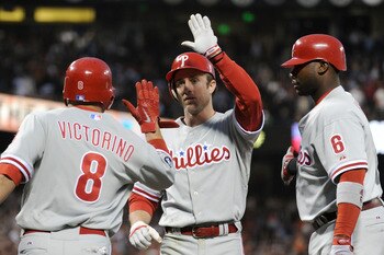 SAN FRANCISCO - OCTOBER 20:  (L-R) Shane Victorino #8, Chase Utley #26, and Ryan Howard #6 of the Philadelphia Phillies celebrate after Victorino and Utley scored on a double by Placido Polanco #27 against the San Francisco Giants in Game Four of the NLCS