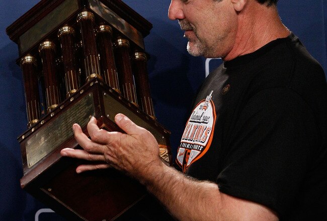 PHILADELPHIA - OCTOBER 23:  Manager Bruce Bochy of the San Francisco Giants celebrates with the trophy after defeating the Philadelphia Phillies 3-2 and winning the pennant in Game Six of the NLCS during the 2010 MLB Playoffs at Citizens Bank Park on Octo