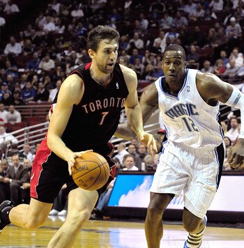 ORLANDO, FL - DECEMBER 16:  Andrea Bargnani #7 of the Toronto Raptors drives past Dwight Howard #12 of the Orlando Magic during the game at Amway Arena on December 16, 2009 in Orlando, Florida.  NOTE TO USER: User expressly acknowledges and agrees that, b