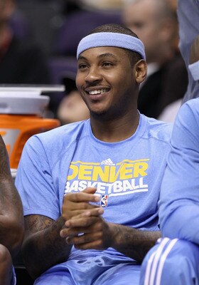 PHOENIX - OCTOBER 22:  Carmelo Anthony #15 of the Denver Nuggets smiles on the bench during the preseason NBA game against the Phoenix Suns at US Airways Center on October 22, 2010 in Phoenix, Arizona. NOTE TO USER: User expressly acknowledges and agrees