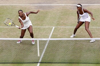 LONDON, ENGLAND - JUNE 30:  Serena Williams (L) and Venus Williams of USA in action during their Quarter Final doubles match against Elena Vesnina and Vera Zvonareva of Russia on Day Nine of the Wimbledon Lawn Tennis Championships at the All England Lawn