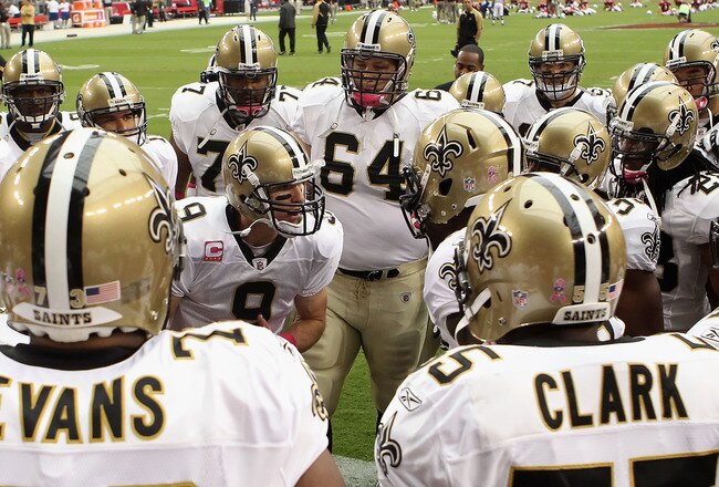 GLENDALE, AZ - OCTOBER 10:  Quarterback Drew Brees #9 of the New Orleans Saints talks with teammates in a huddle prior to the NFL game against the Arizona Cardinals at the University of Phoenix Stadium on October 10, 2010 in Glendale, Arizona. The Cardina