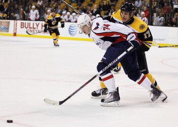 BOSTON - SEPTEMBER 29: Milan Lucic #17 of the Boston Bruins and John Carlson #74 of the Washington Capitals fight for the puck on September 29, 2010 at the TD Garden in Boston, Massachusetts. The Capitals defeated the Bruins 4-1.  (Photo by Elsa/Getty Ima