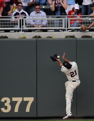 MINNESOTA, MN - APRIL 12: Delmon Young #21 of the Minnesota Twins bobbles the ball allowing Kevin Youkilis #20 of the Boston Red Sox to score in the fourth inning against the Boston Red Sox during the Twins home opener at Target Field on April 12, 2010 in