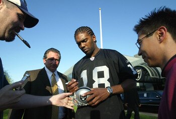 ALAMEDA, CA - MARCH 02:  New Oakland Raiders wide receiver Randy Moss #18 signs autographs after speaking at a news conference March 2, 2005 in Alameda, California. The former Minnesota Vikings was introduced by his new team today and the Raiders are work