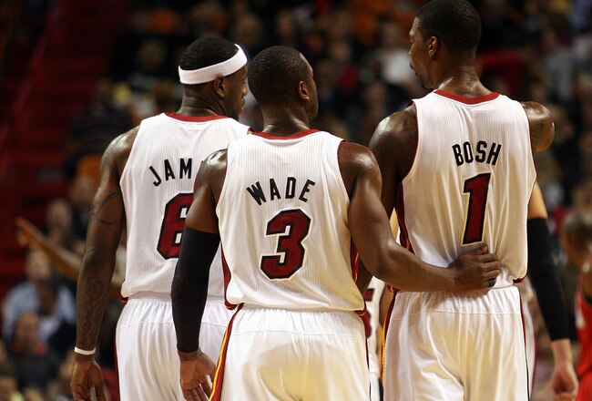 MIAMI - NOVEMBER 06: Dwyane Wade #3, LeBron James #6 and Chris Bosh #1 of the Miami Heat chat during a game against the New Jersey Nets  at American Airlines Arena on November 6, 2010 in Miami, Florida. NOTE TO USER: User expressly acknowledges and agrees